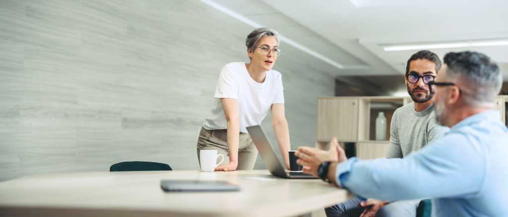 Group of business professionals having a discussion during a meeting. Three businesspeople sharing ideas while working together in a modern co-working office.